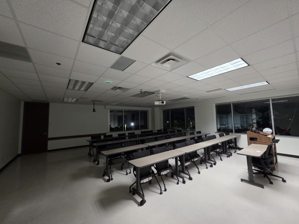 Alternate angle of the hybrid classroom showing the ceiling-mounted projector and back-of-room camera placement.